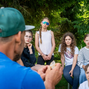 Aufmerksame Schüler:innen an einer der Wissensstationen mit Ranger Roland Fricker. © NPHT/Florian Kreidl-Glück